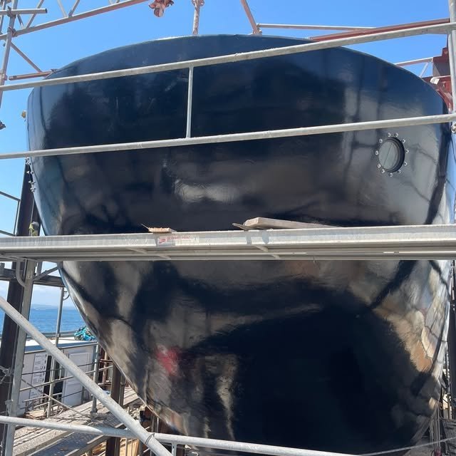 The shiny black hull of the Heraclitus after painting.