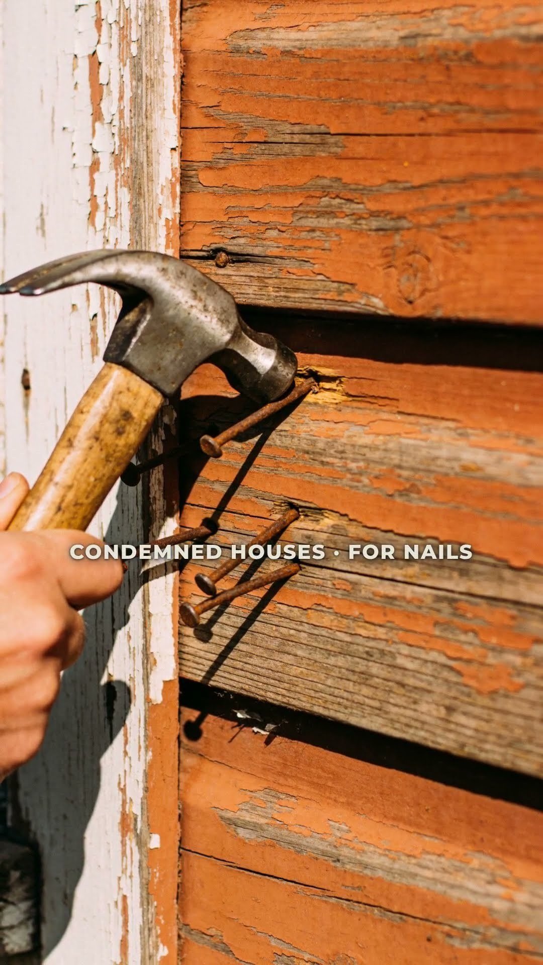 Still from episode 13, A Café Paid For the First One — a claw hammer pulling nails from weathered, peeling siding